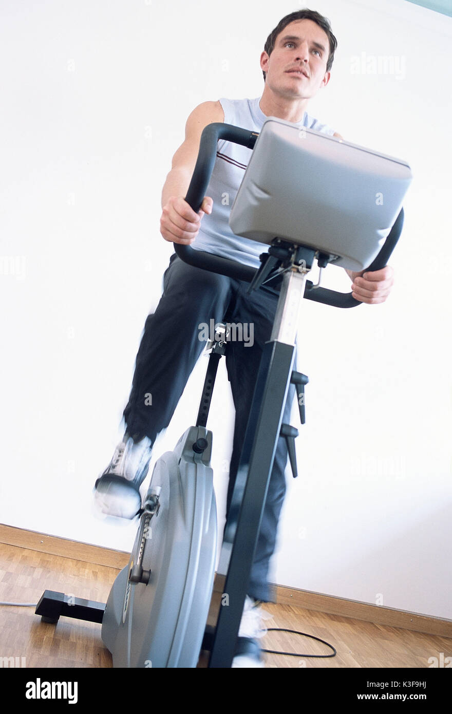 Young man on bicycle ergometer Stock Photo