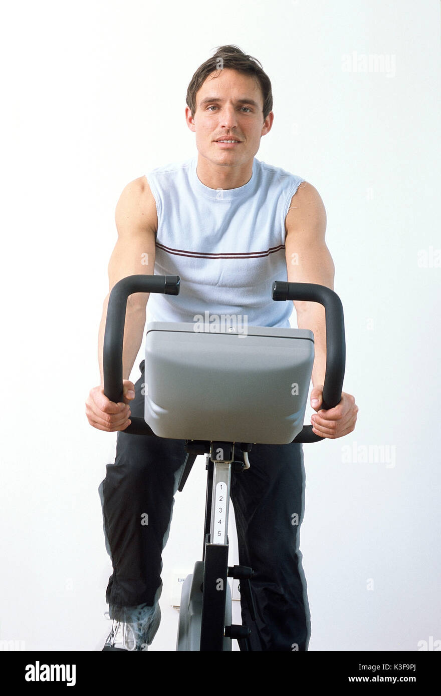 Young man on bicycle ergometer Stock Photo