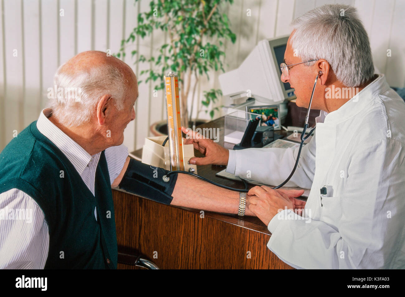Doctor measures to an old man the blood pressure Stock Photo