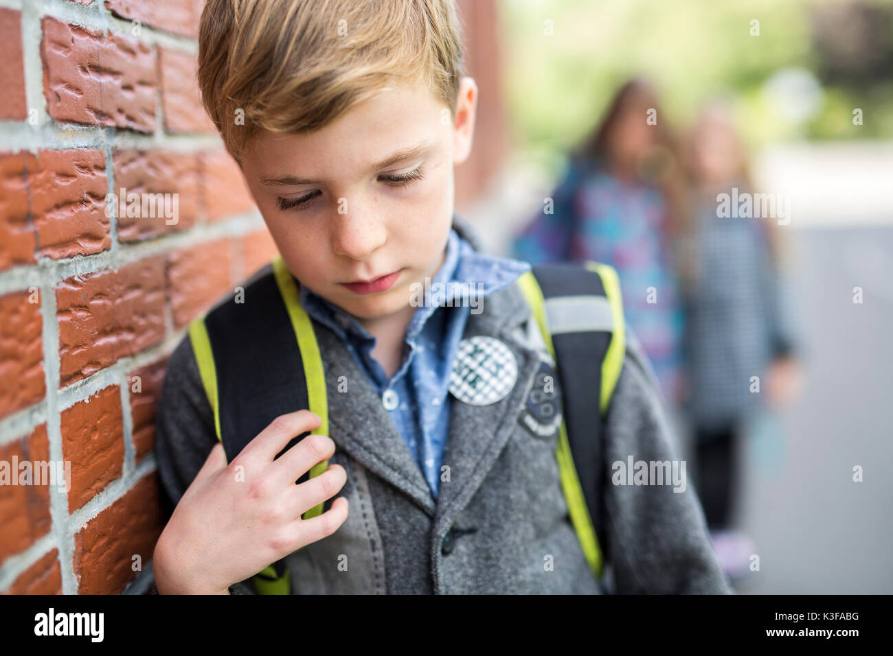Pupils friends teasing a pupil alone primary school Stock Photo