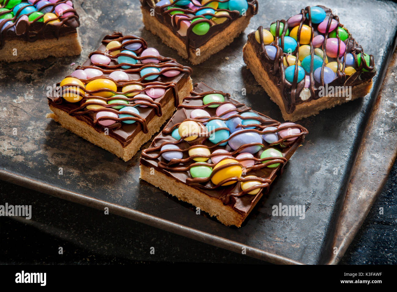Two Colorful Shortbread Candy Bars Drizzled with Chocolate on Baking Sheet Stock Photo