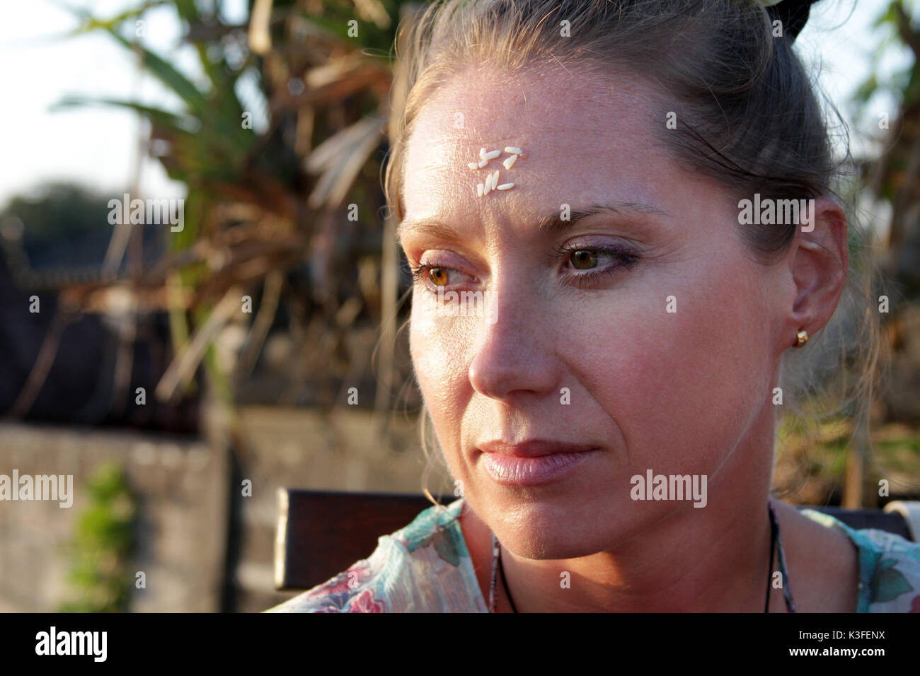 Portrait of a woman with rice on her forehead. Rice on the forehead after the end of prayer is a symbol of longevity, prosperity and closeness to God Stock Photo
