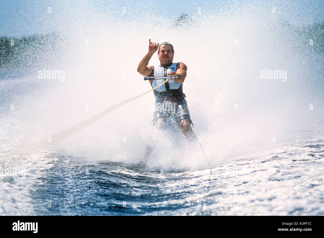 Barefooted water-ski driver shows Hang-Loose gesture Stock Photo