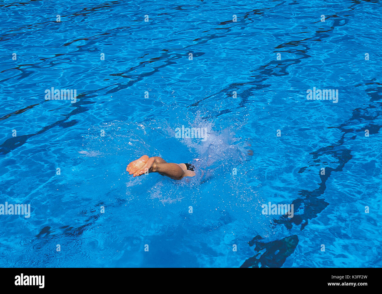 swimmer shortly after dipping into the swimming pool Stock Photo