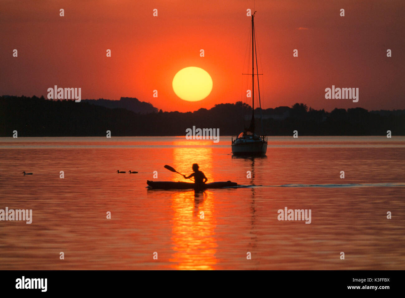 Kayakist in front of sundown in Ammersee Stock Photo