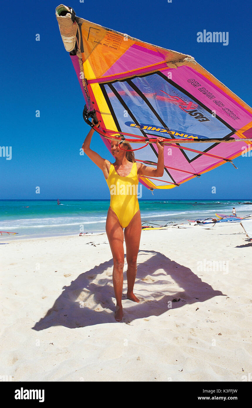 Woman carries surfing sail Stock Photo