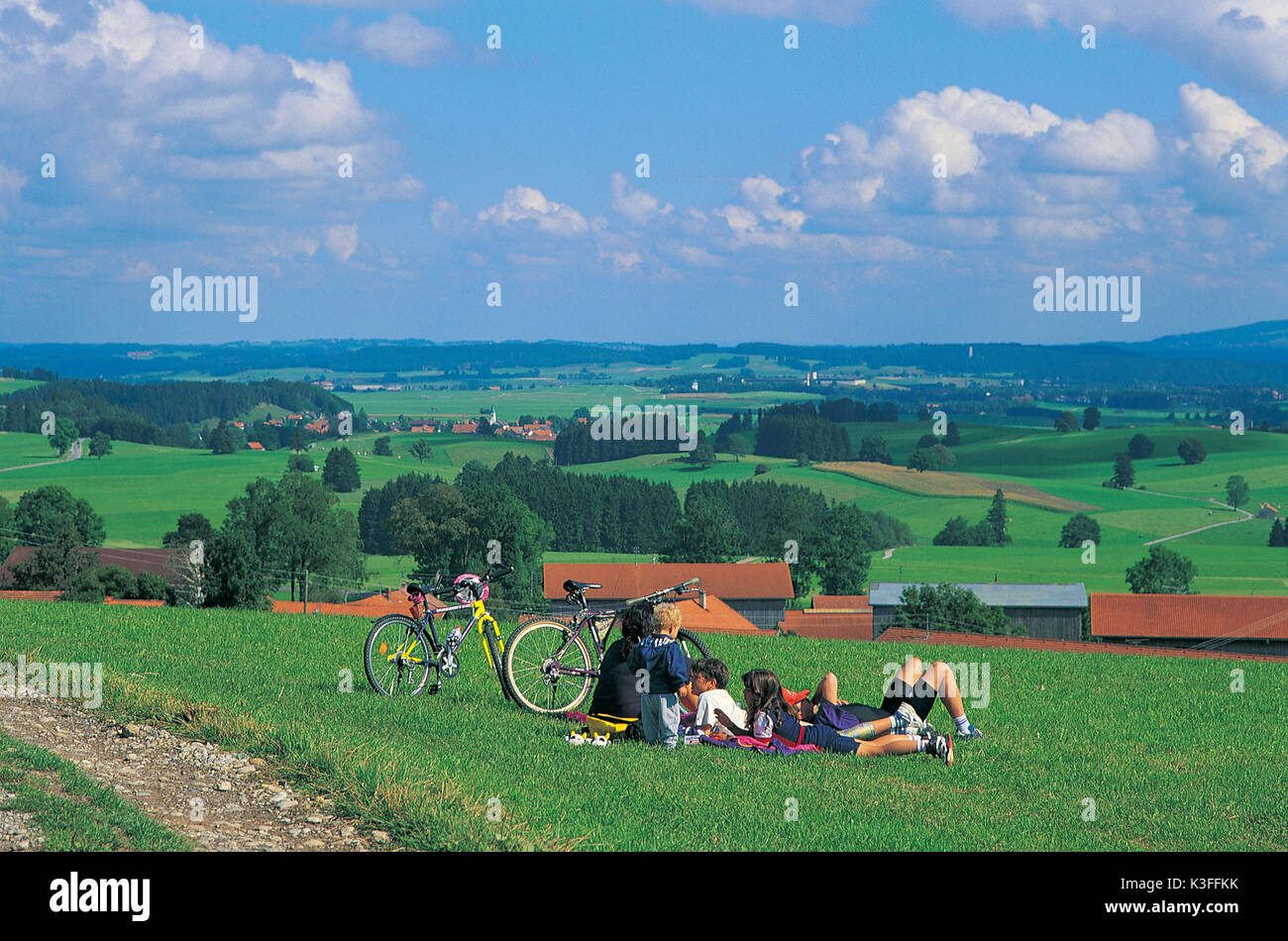 Cyclist at a break on a meadow Stock Photo