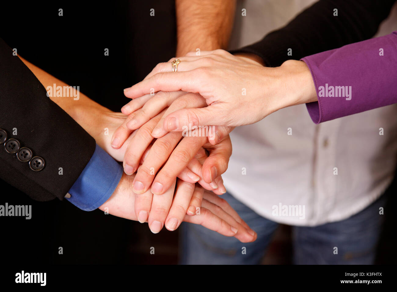 group of employees hands together teamwork dedication Stock Photo