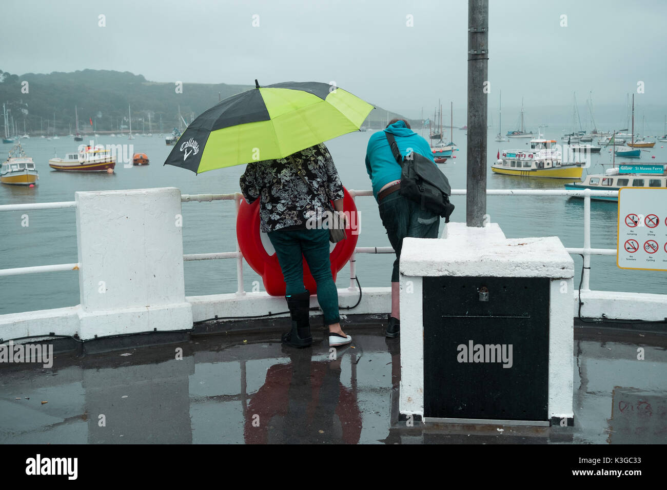 Falmouth, UK. 03rd Sep, 2017. A couple enjoy a wet walk along the Prince of Wales Pier, Falmouth Cornwall under a nice big golf umbrella as rain sets in on last weekend of the traditional summer holidays. Credit: Mick Buston/Alamy Live News Stock Photo
