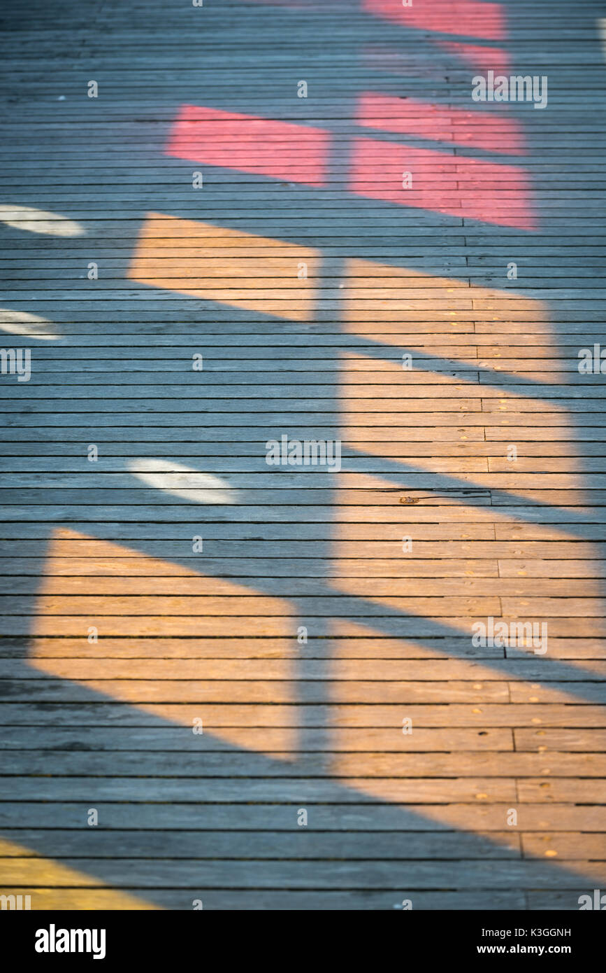 Colourful patterns, caused by the sun shining through stained glass windows, on the decking at