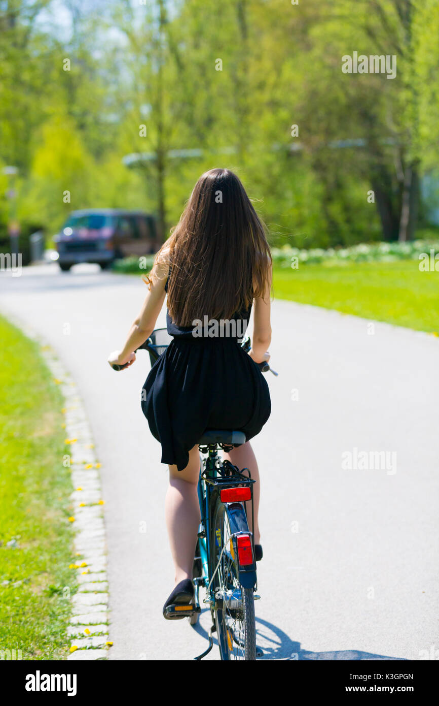 Back View Of Girl On Bicycle Wearing On Black Short Dress