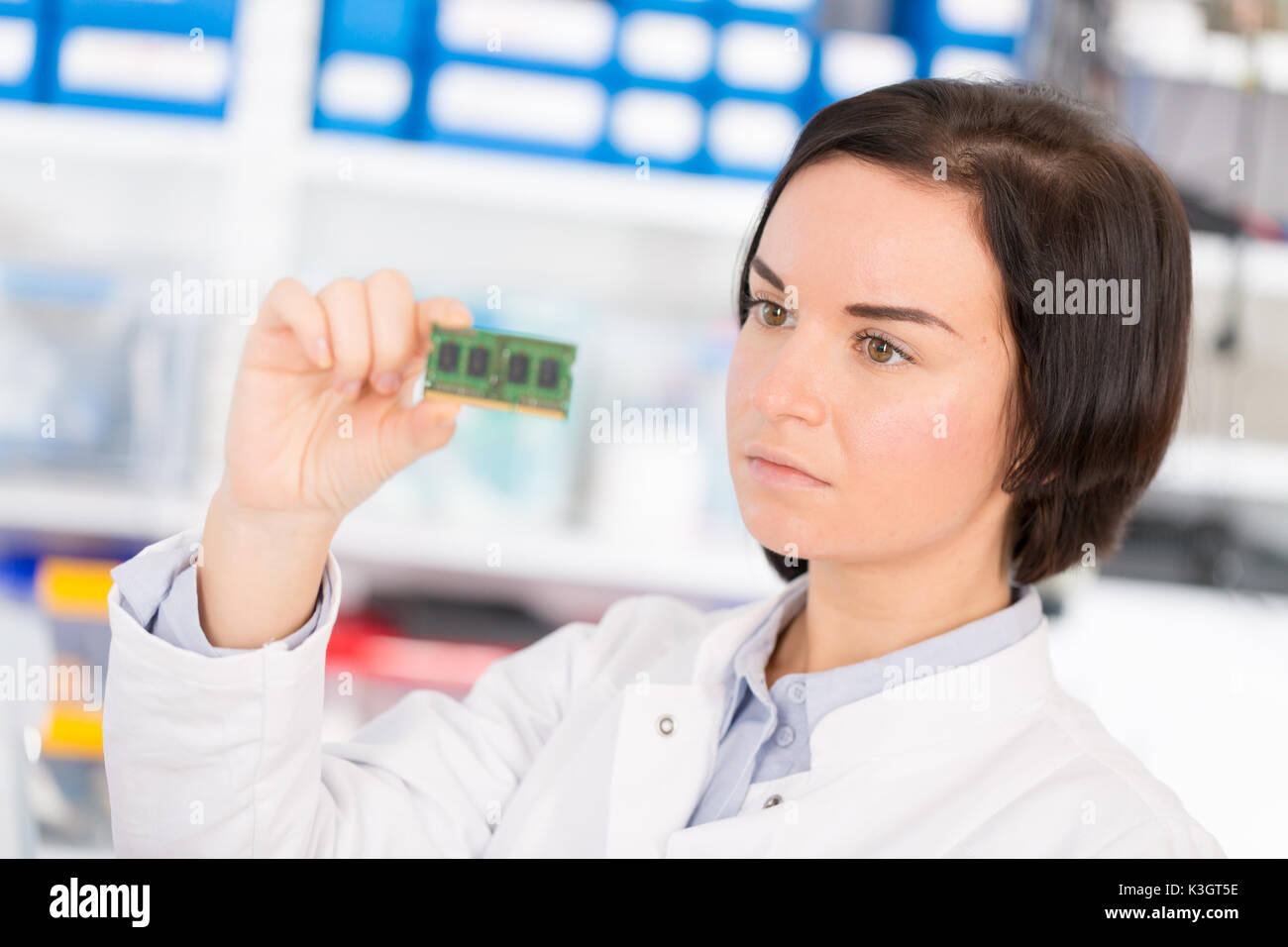 Female laboratory assistant Repairs PCB module for CNC robotics. Measurement of the parameters of the electronic system in the laboratory Stock Photo