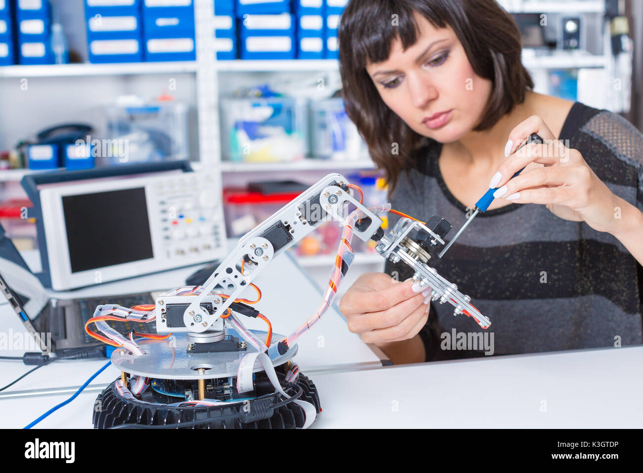 Female in robotics laboratory. Young woman experiment with robot Stock Photo