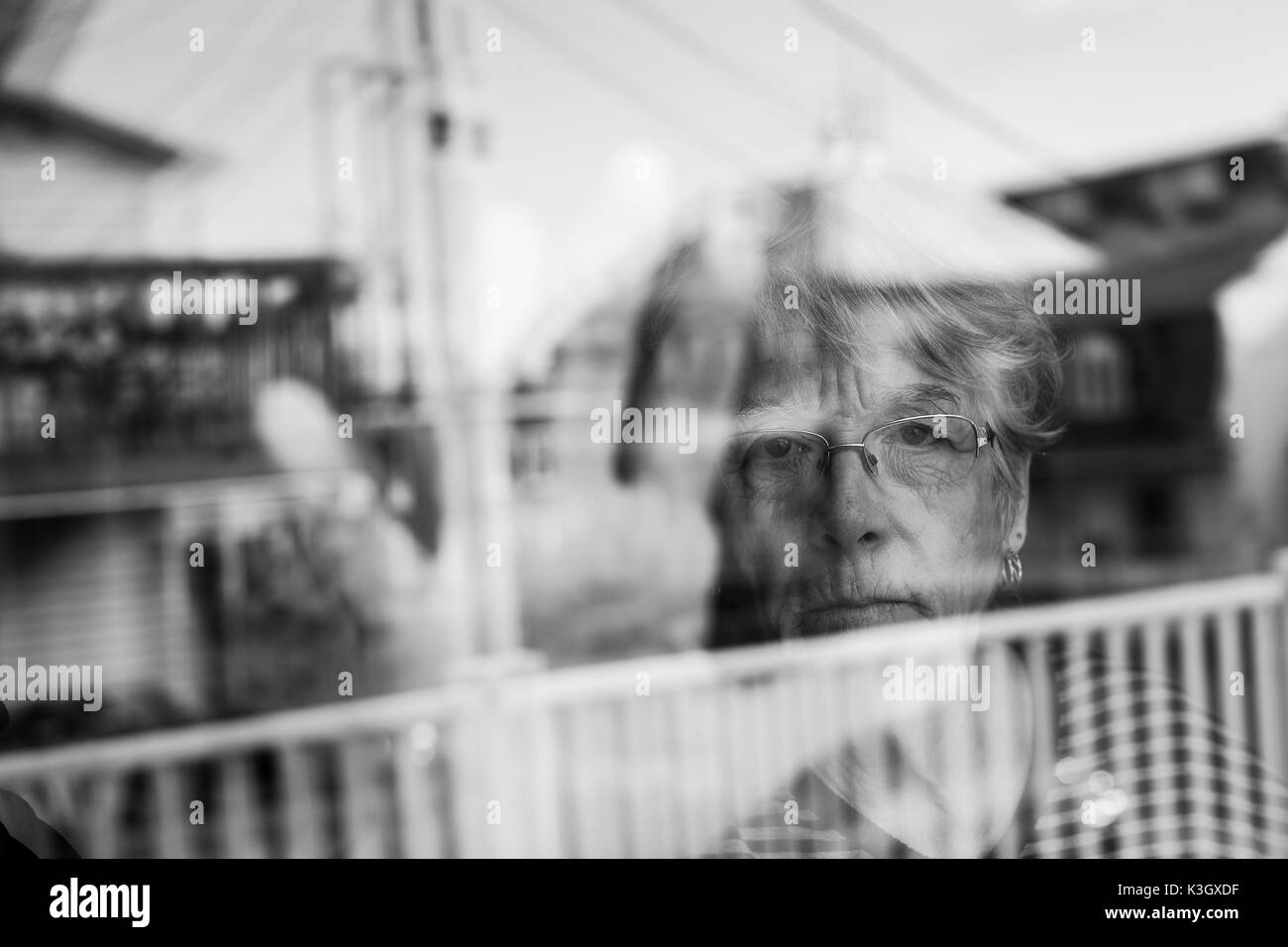 Senior woman looking out through a window like depress Stock Photo
