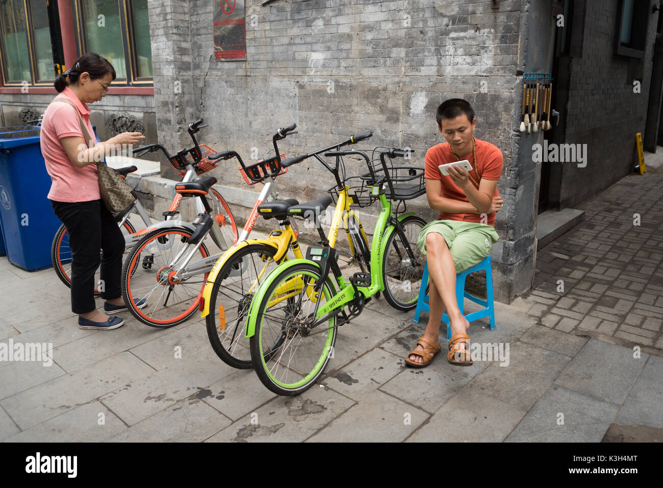 Beijing, China-July 22, 2017: Unidentified young Chinese man and woman with their smart phone in their neighborhood street of Beijing. Stock Photo
