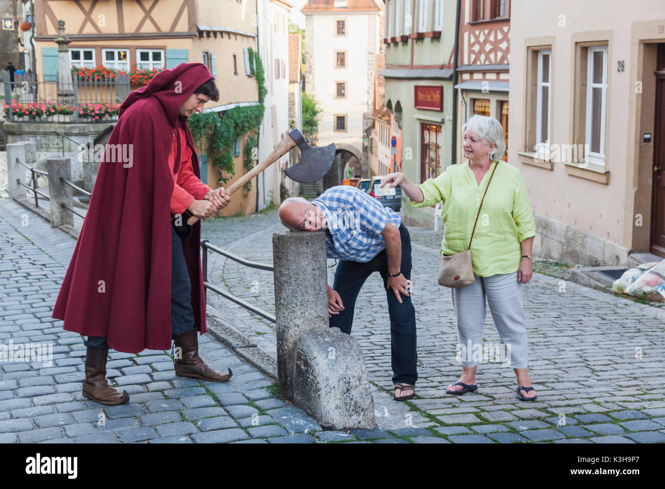 Germany, Bavaria, Romantic Road, Rothenburg-ob-der-Tauber, Tourists and Guide Re-enacting Be-heading Stock Photo