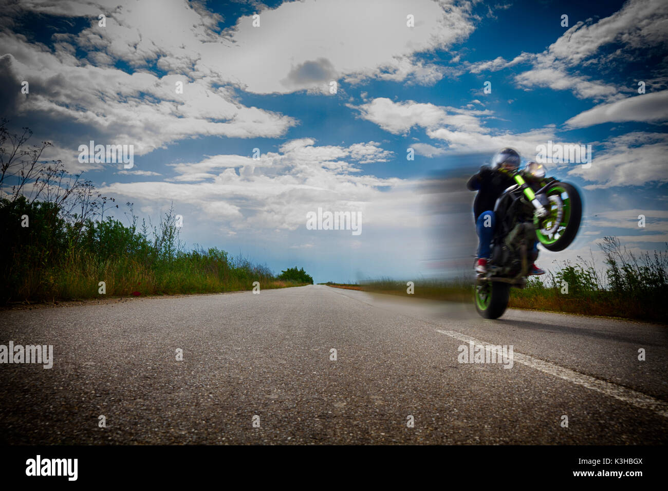 Riding Motorcycle On One Wheel On Empty Road And Clowdy Blue Sky Stock Photo Alamy Riding Motorcycle On One Wheel On Empty Road And Clowdy Blue Sky Stock Photo Alamy