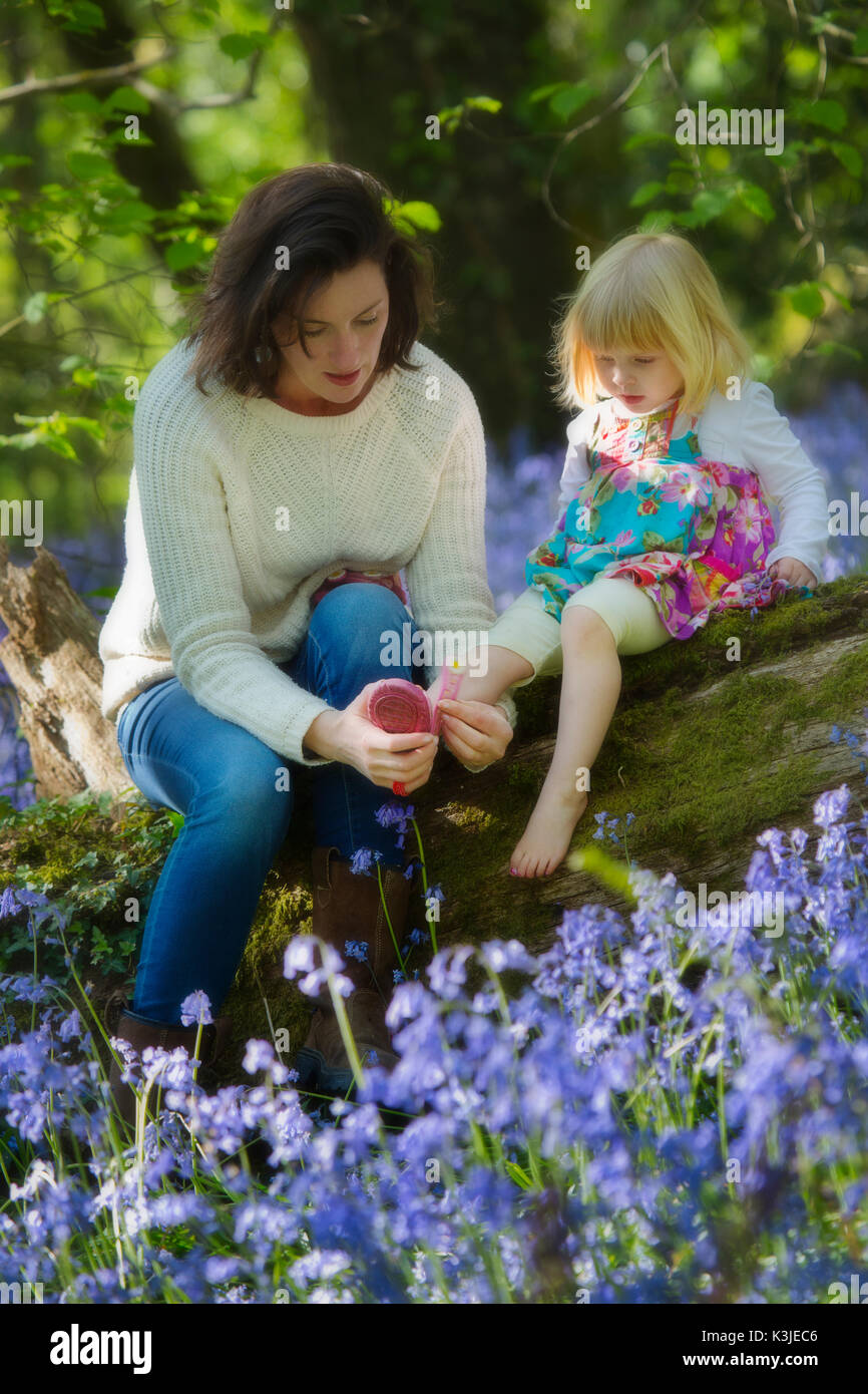 A young mother with her child in a bluebell wood in Devon,England UK Stock Photo