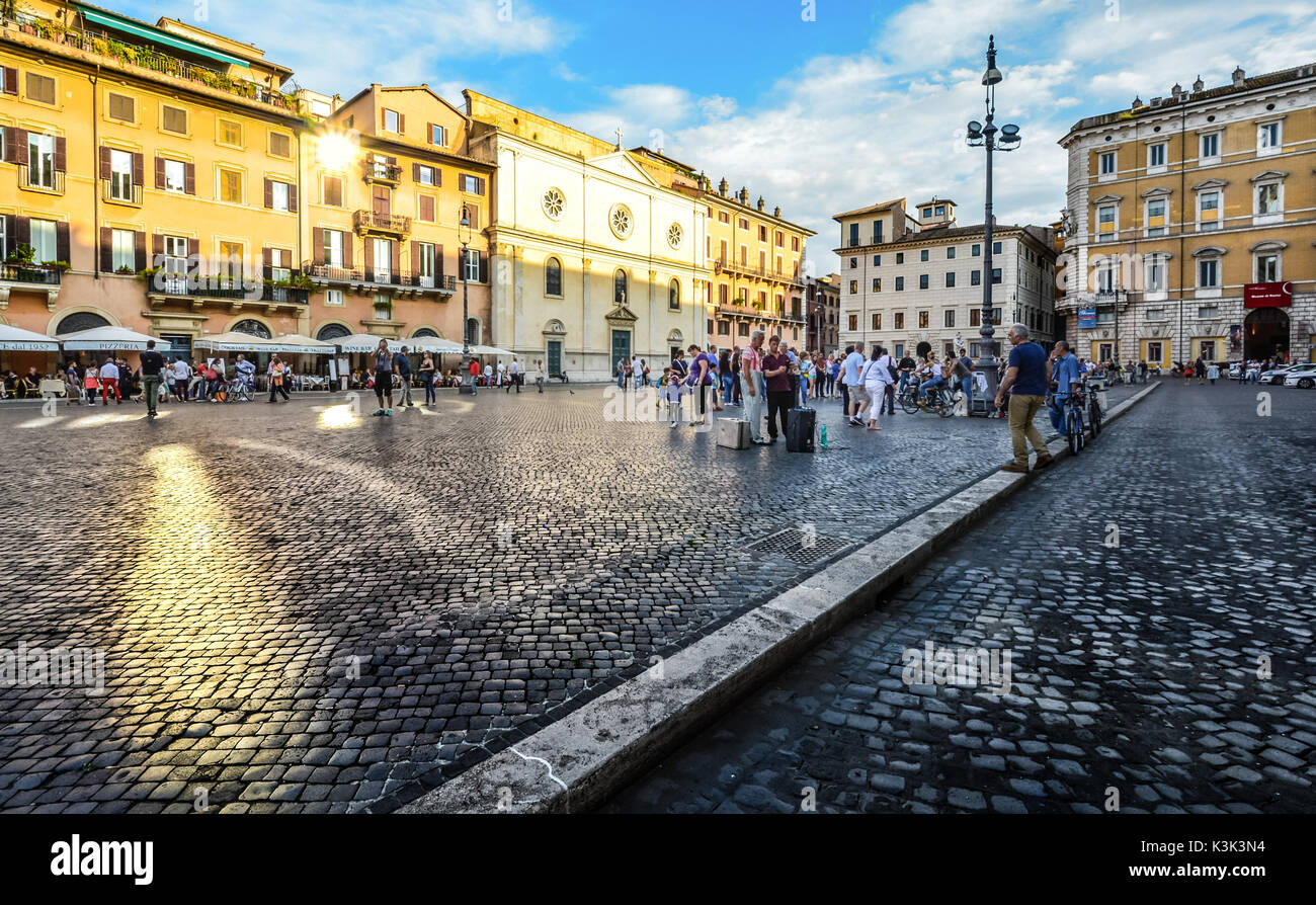 Late afternoon on the Piazza Navona as the sunlight shines off a window and locals and tourists enjoy themselves Stock Photo