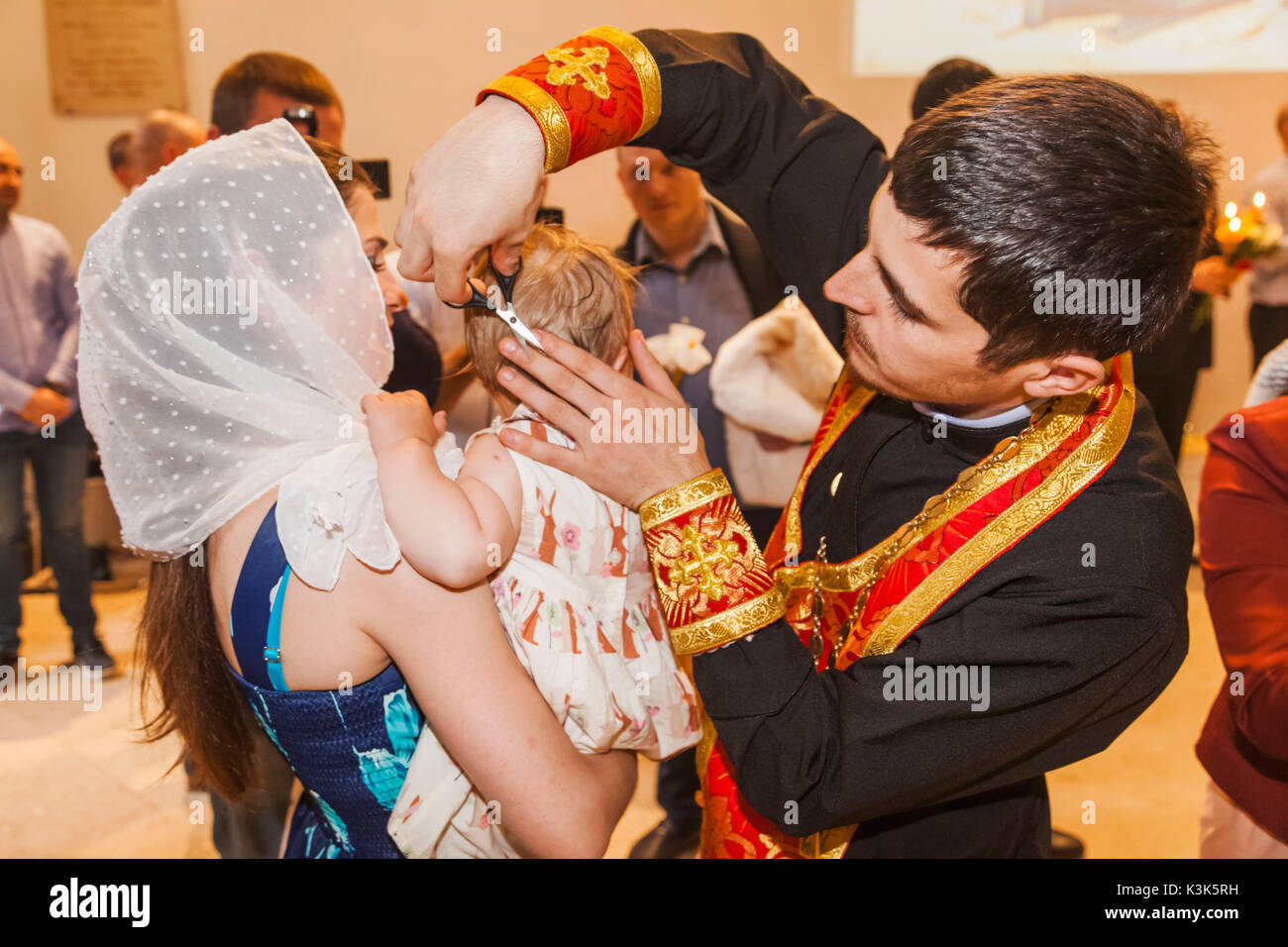 England, London, The City, Bishopsgate, St.Nicholas Orthodox Church, Baptismal and First Hair Cutting Ceremony, Orthodox Priest Cutting Baby's Hair Stock Photo