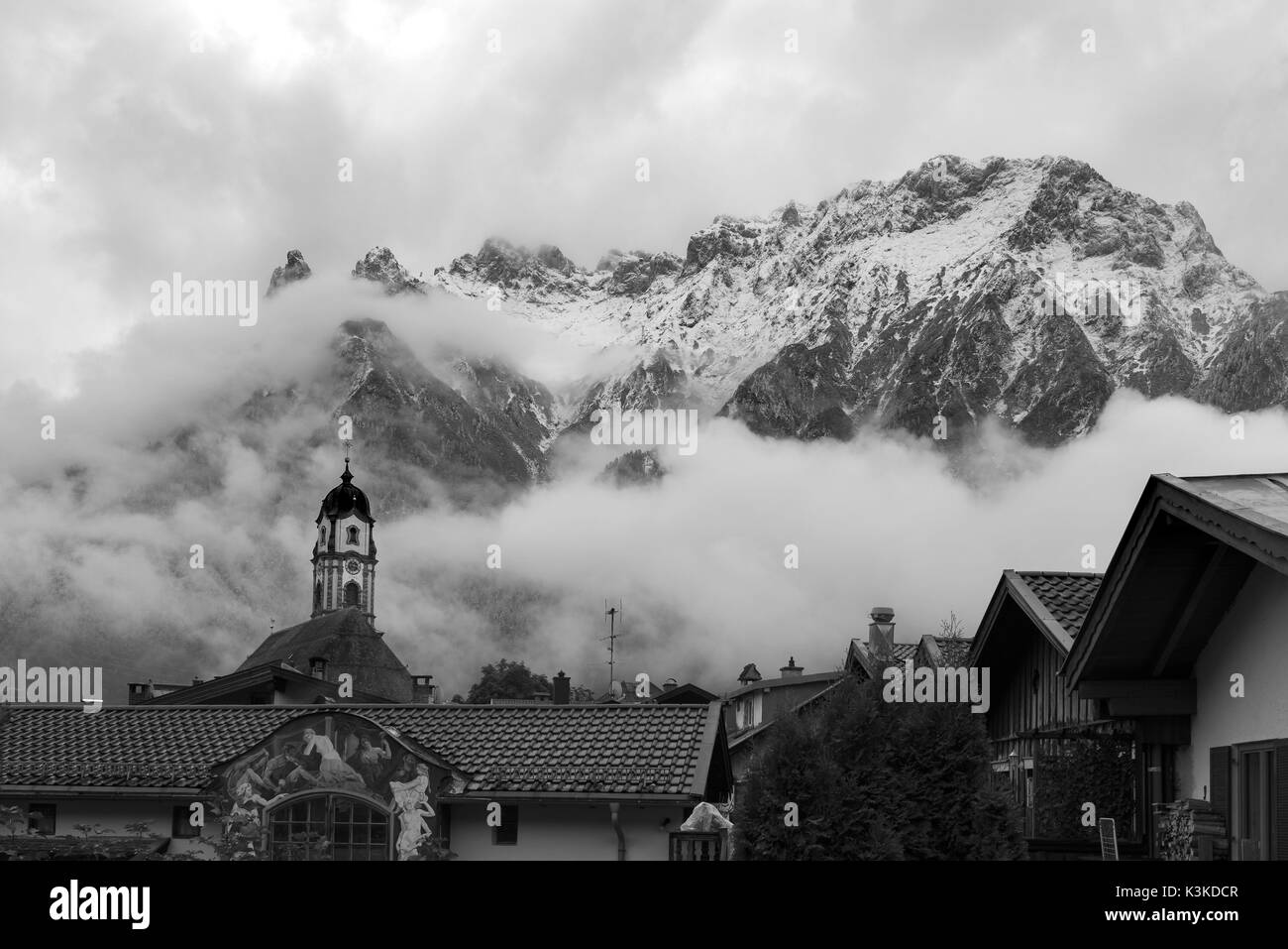 Roofs and steeple of the violin maker village Mittenwald in front of the Karwendelgebirge (mountains) with beautyful clouds. Stock Photo