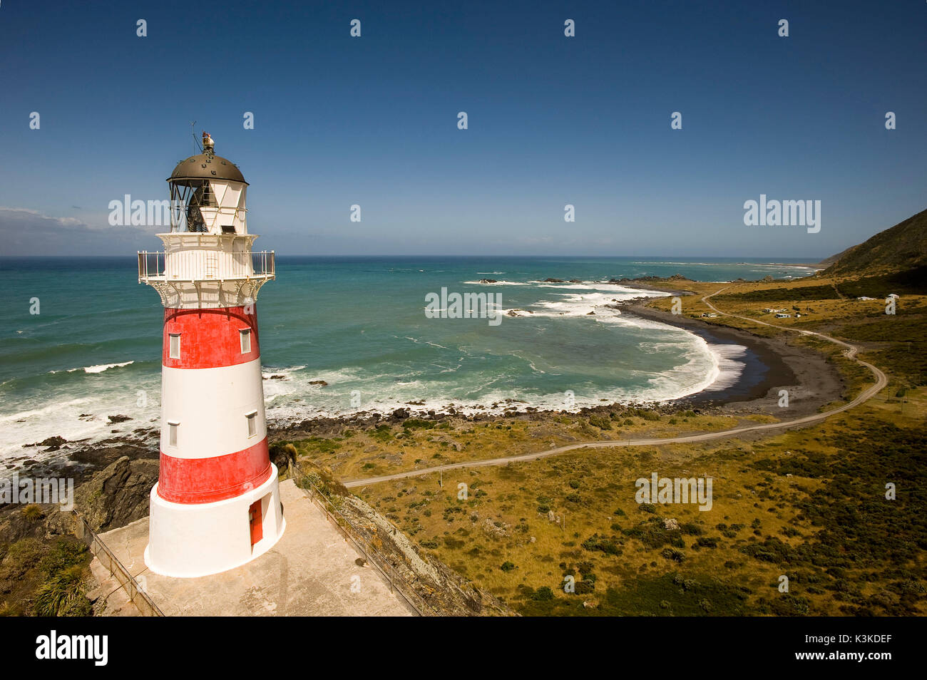 The lighthouse of cape Palliser at the southern end of the north island of New Zealand with bringing streeds and settlement. Stock Photo