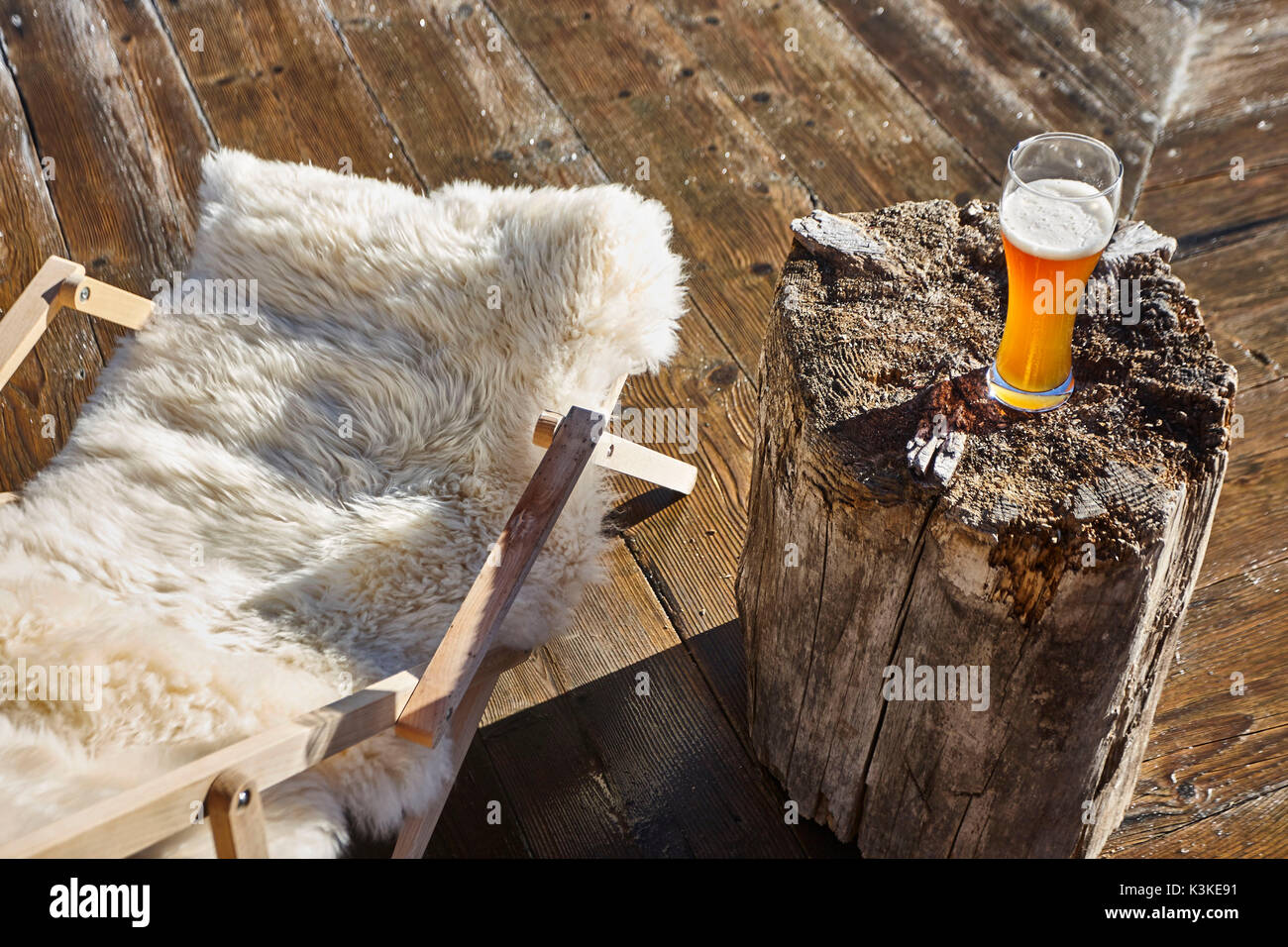Terrace, deck chair with fur, wheat beer on chunk of wood, from above, winter, Stock Photo
