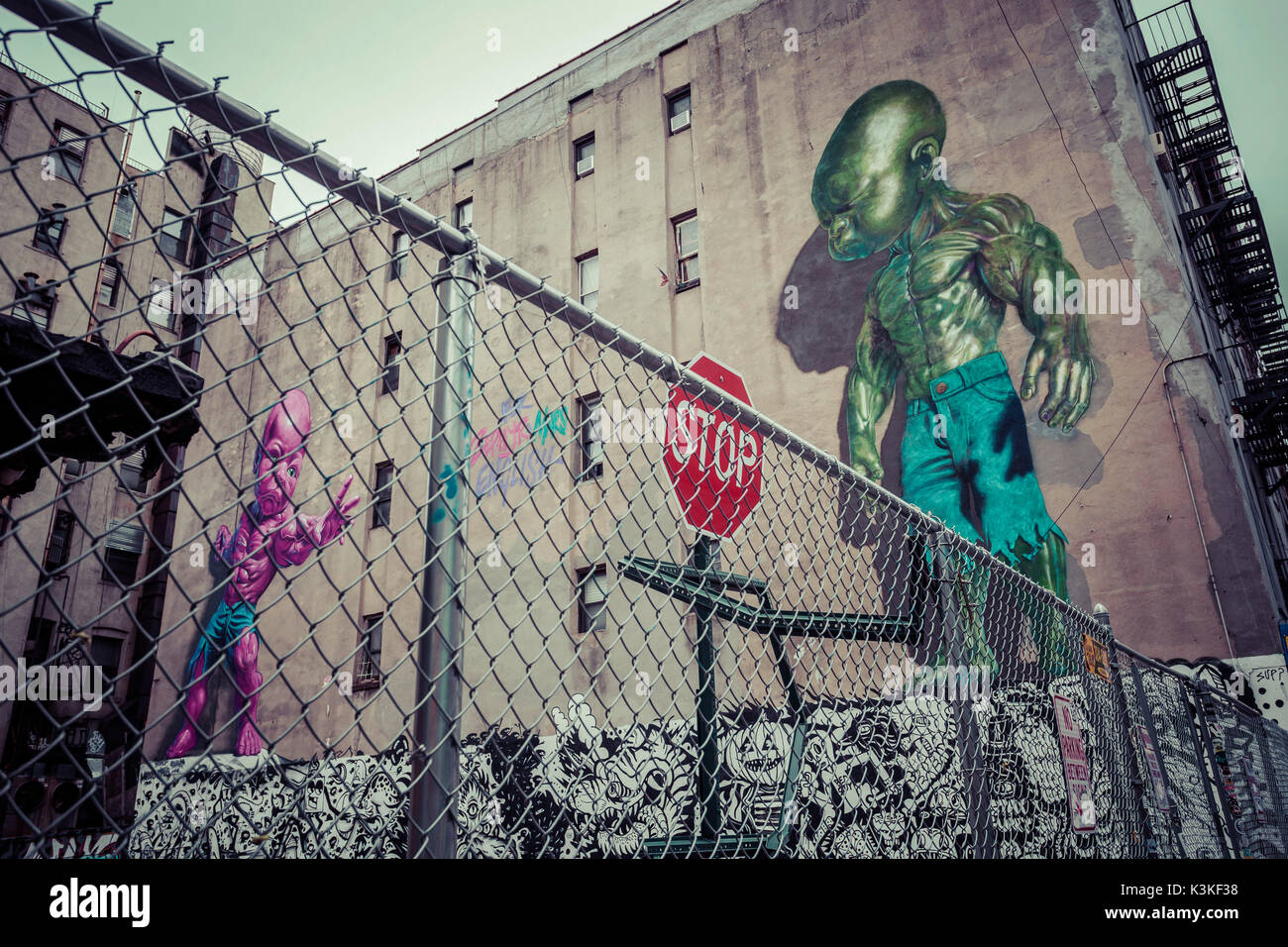 Backyard scene Graffiti of a pink and green superpower baby, Little Italy, Manhatten, New York, USA Stock Photo