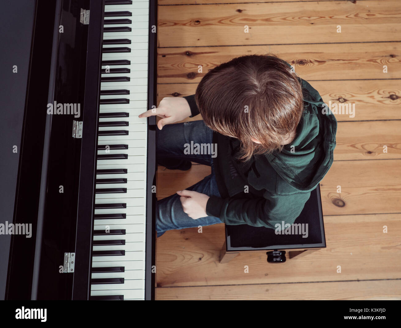 Portrait of a boy playing on a black digital piano - high angle view Stock Photo