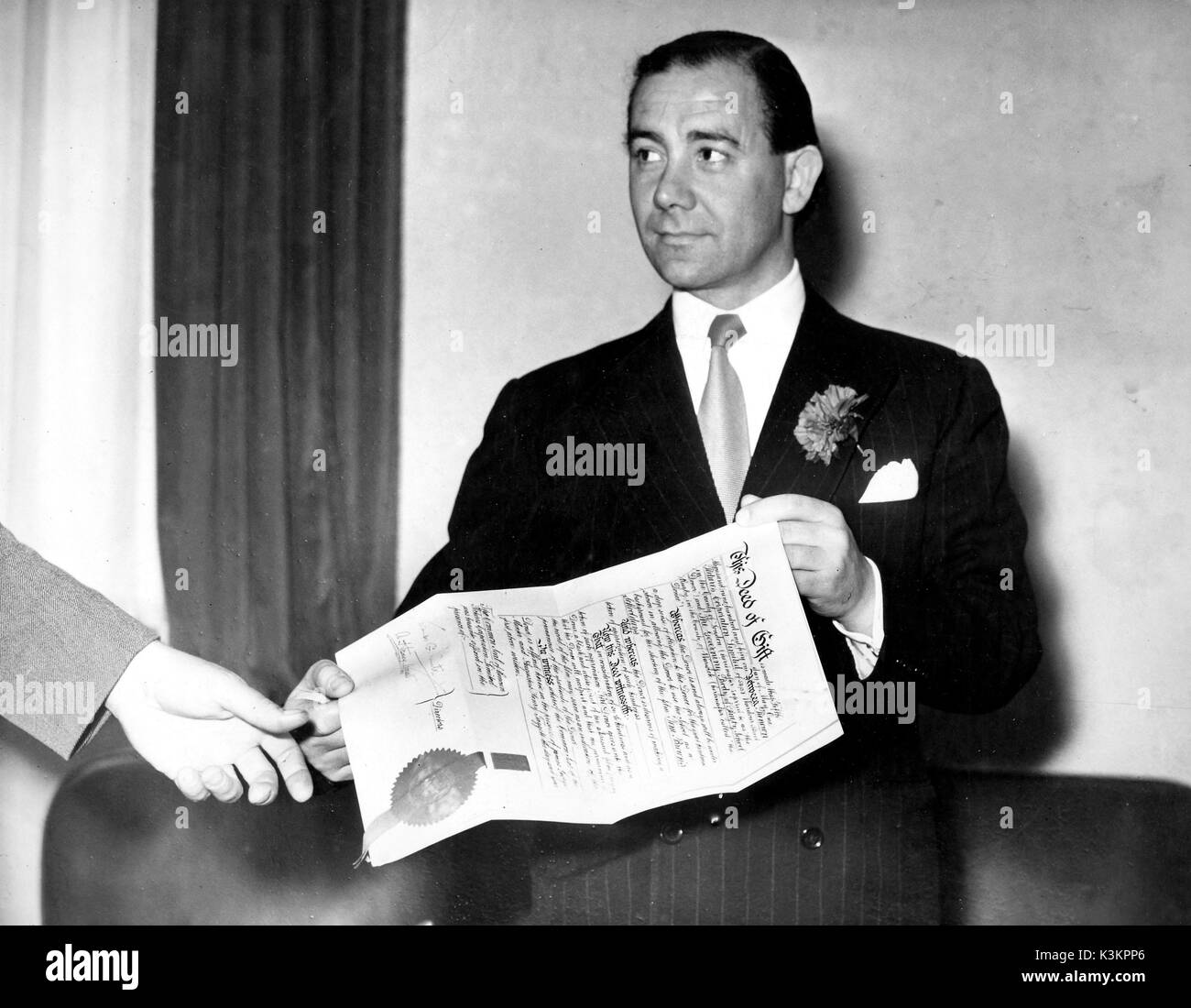 GEORGE MINTER [1911 - 1966]  British film producer and head of Renown Pictures a film producing and distributing company, seen here with a document registering the co-operation of the governing body of Rugby School where Renown filmed Tom Brown's Schooldays [Br 1951] was set in the school. Stock Photo