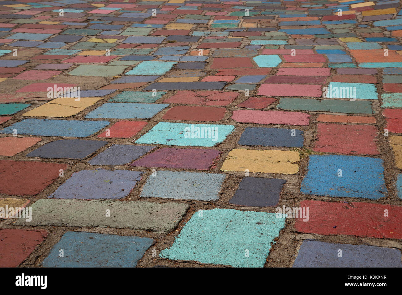 Multicolored painted concrete pavers cover the surface of the plaza of Spanish Village in Balboa Park, San Diego; good for background, copy space. Stock Photo