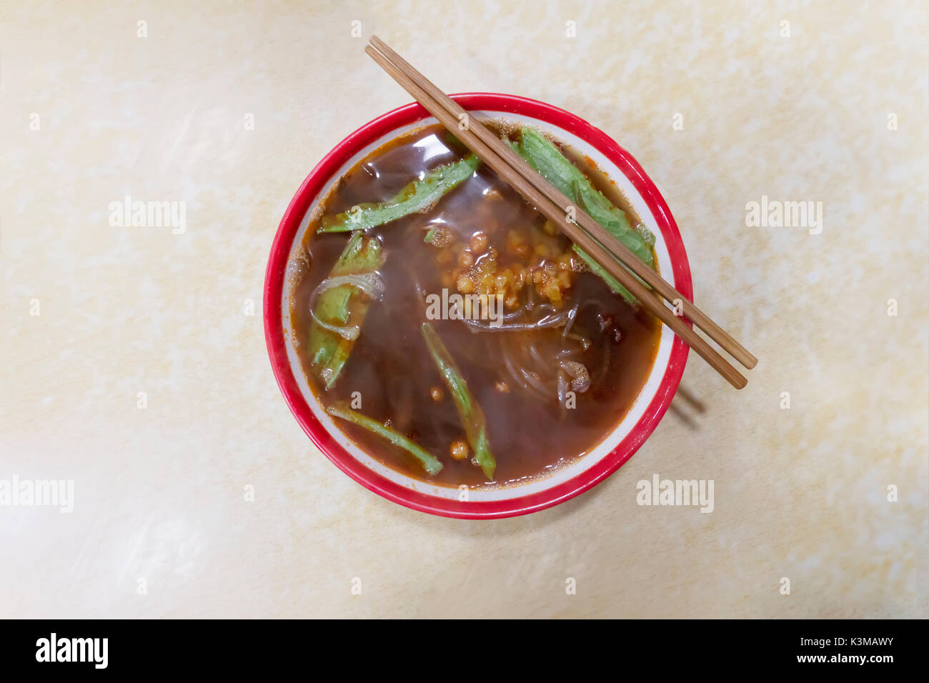 chinese noodles in a red bowl and chopsticks Stock Photo