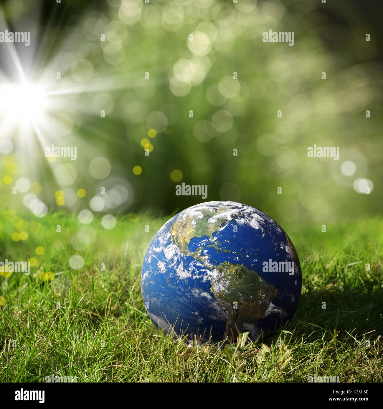 conceptual image of globe on green landscape and light. Furnished NASA image used for this image. Stock Photo