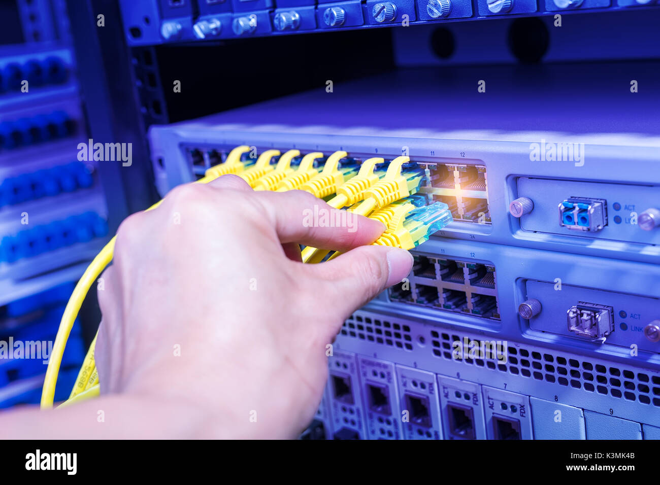 hand with network cables connected to servers Stock Photo