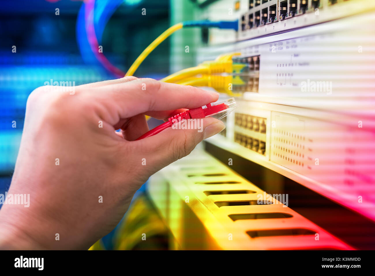 hand with network cables connected to servers Stock Photo