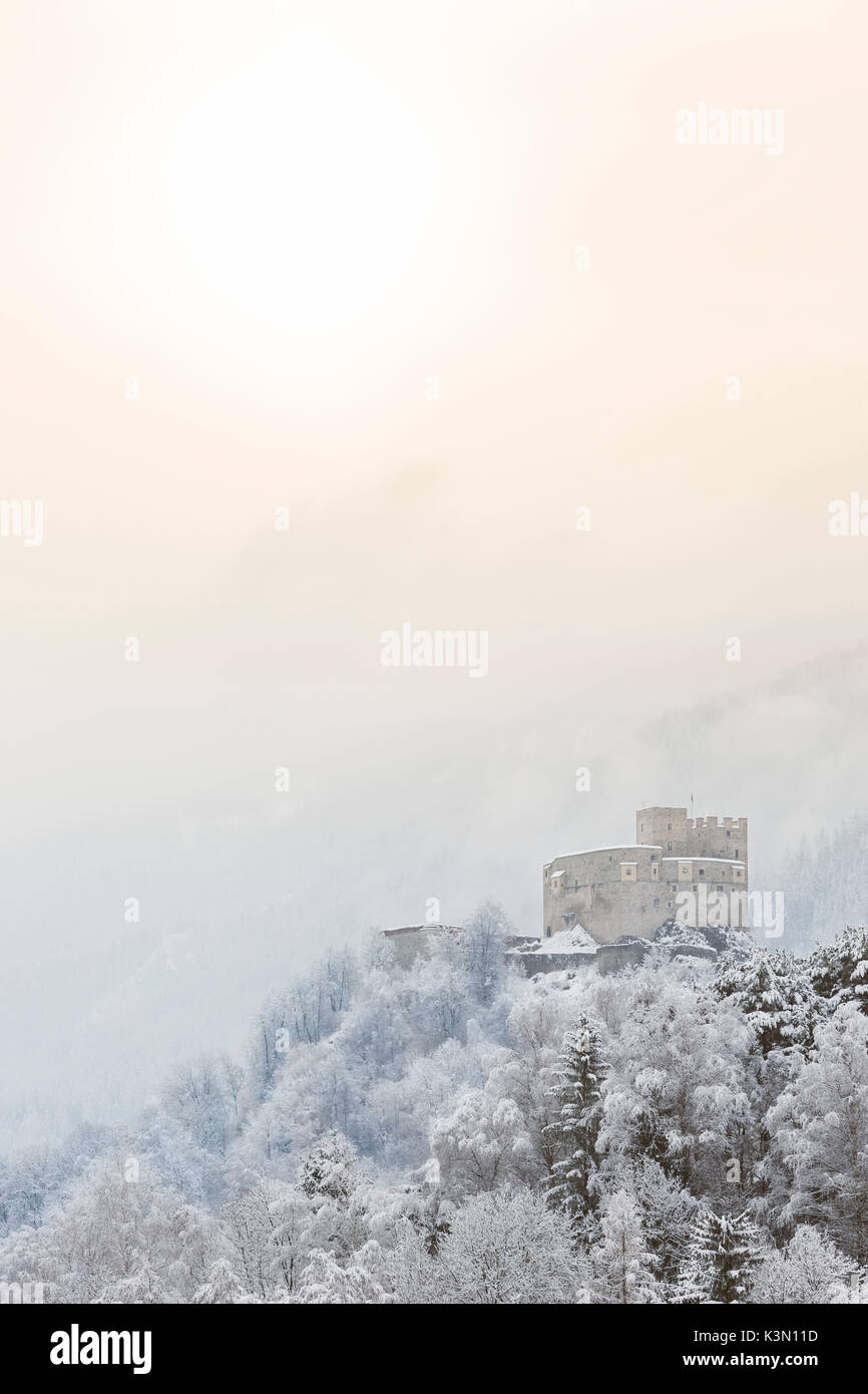 a suggestive winter view of the castle of St. Michael in Bruneck with the first sun going out the mist, Bolzano province, South Tyrol, Trentino Alto Adige, Italy, Europe Stock Photo