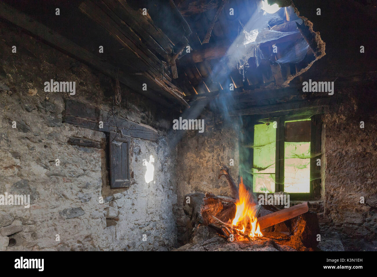 Sedico, Belluno, Veneto, Italy. Fire in the ancient fireplace in one of the many abandoned buildings in the area of Monti del Sole Stock Photo