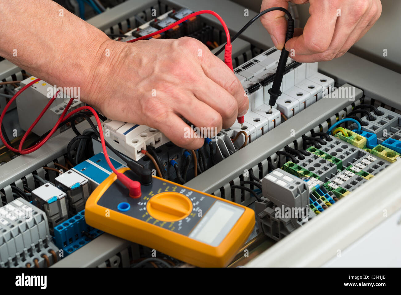 Close-up Of A Male Electrician Checking Fuse With Multimeter Stock Photo