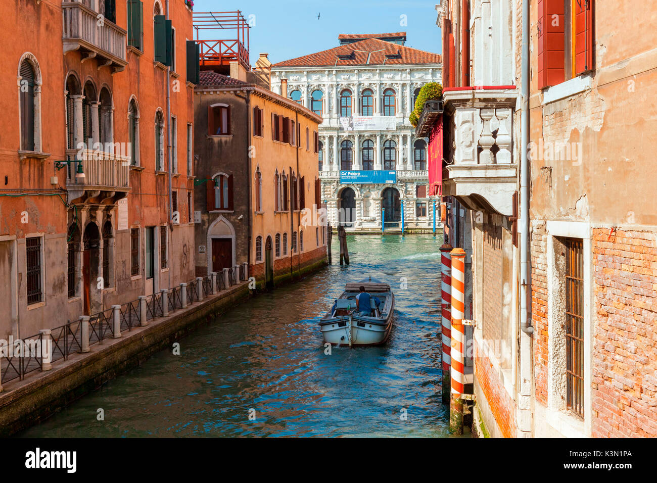 Venice, Italy. Boat between the canals and the historic building of Cà Pesaro in the background. Stock Photo