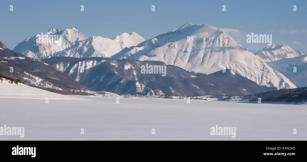 The Gran Sasso d'Italia mountain and the lake of Campotosto completely frozen in a winter day, Abruzzo, Italy Stock Photo