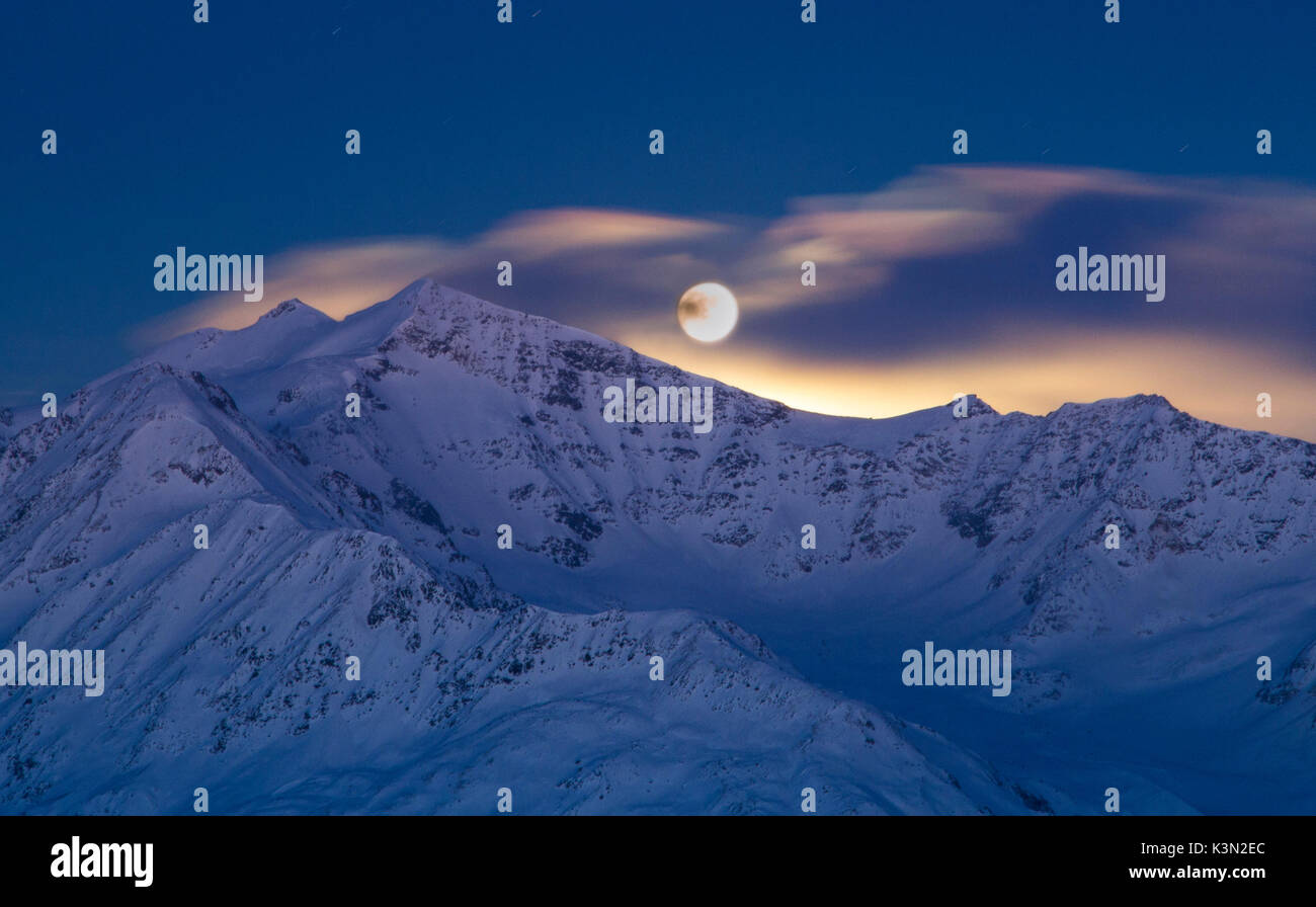 Europe, Italy, Lombardy, Sondrio. Moony sunrise from mount Cevedale in italian Alps of Valfurva Stock Photo