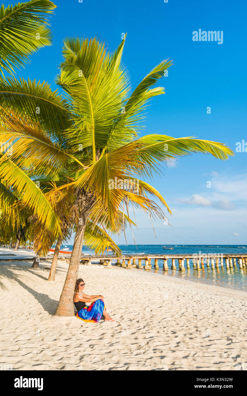 Mano Juan, Saona Island, East National Park (Parque Nacional del Este), Dominican Republic, Caribbean Sea. Woman relaxing on the palm-fringed beach (MR). Stock Photo