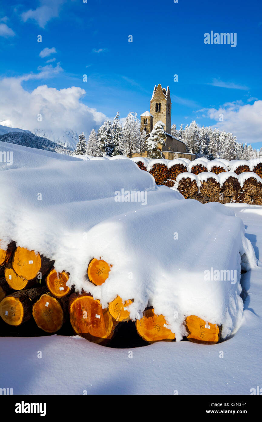Trunks and old church in Celerina with pristine snow. Engadine, Switzerland, Europe Stock Photo