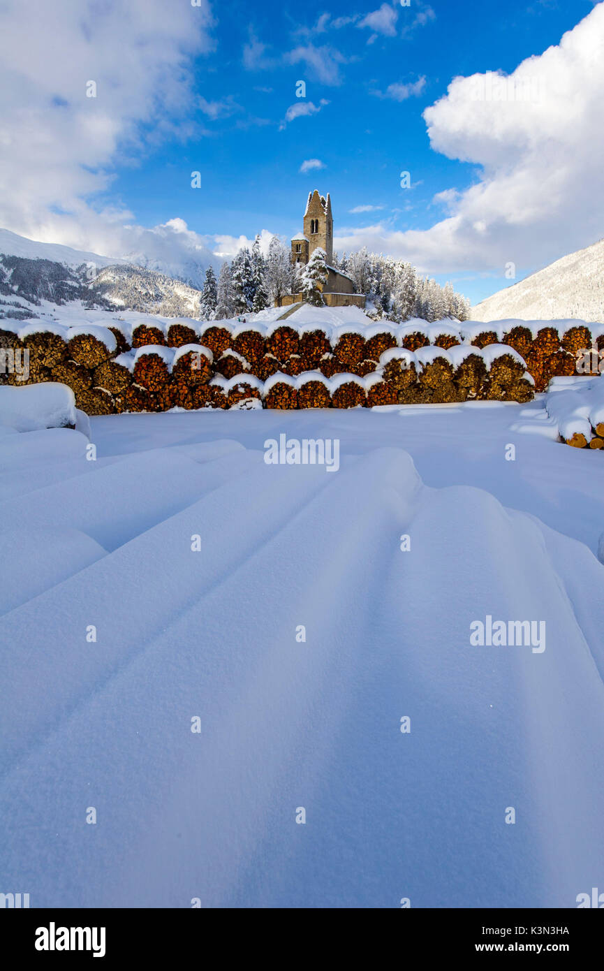 Trunks and old church in Celerina with pristine snow. Engadine, Switzerland, Europe Stock Photo