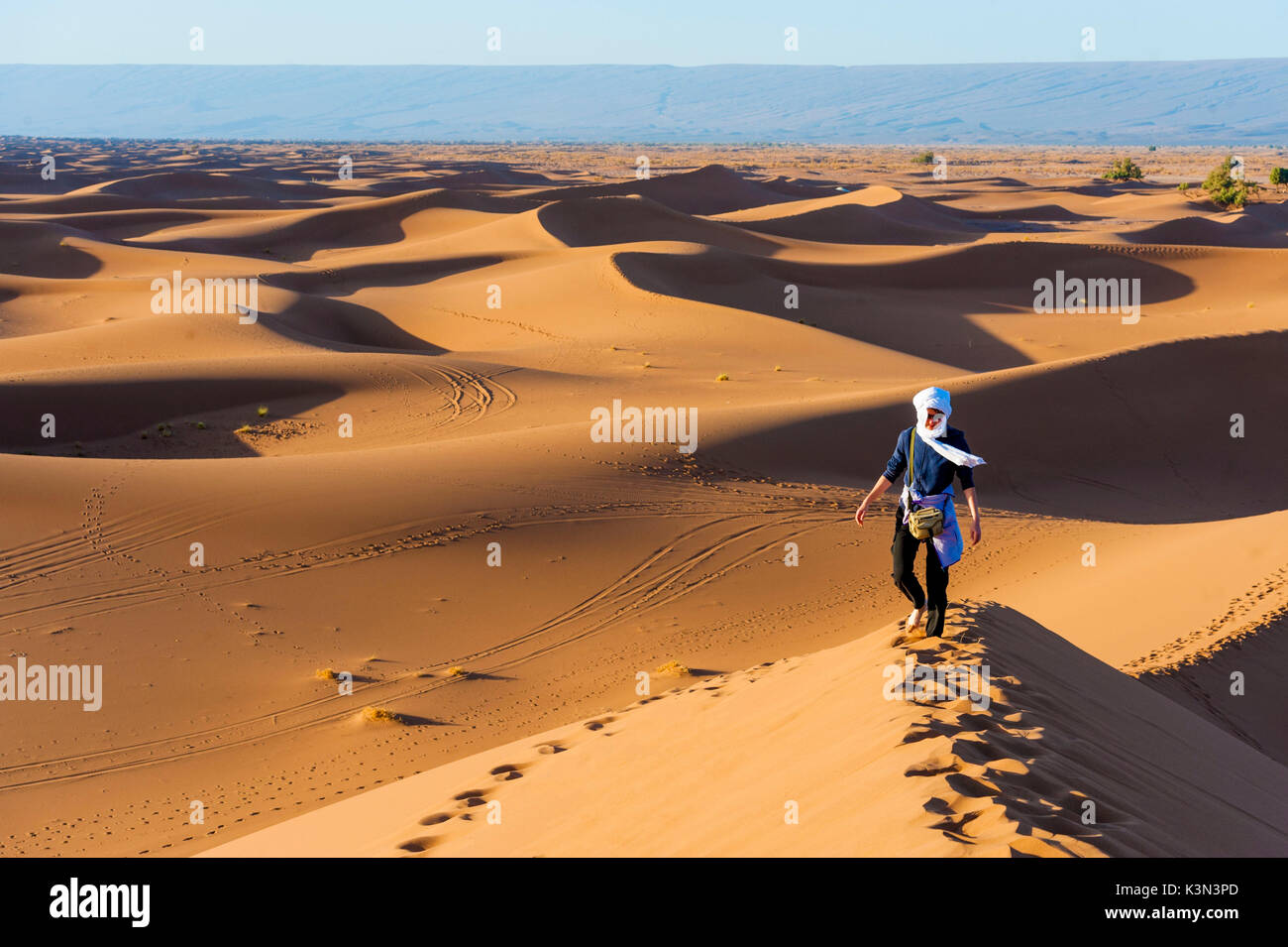 Erg Chigaga, Sahara desert, Morocco. Tourist on top of the dune at sunset. Stock Photo