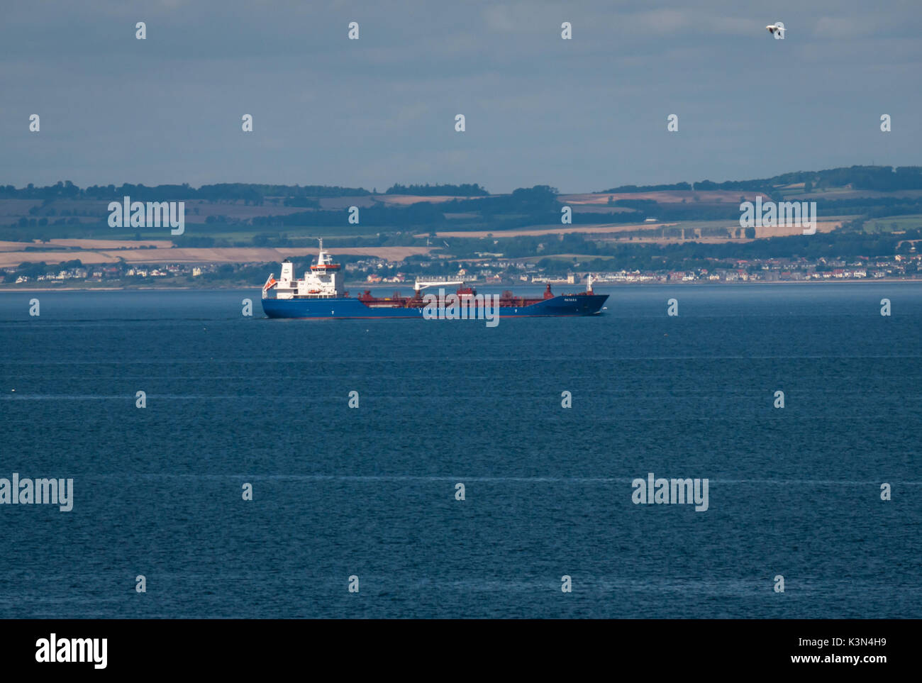 View of container ship in Firth of Forth sailing down the estuary past hills of Fife, Scotland, United Kingdom Stock Photo