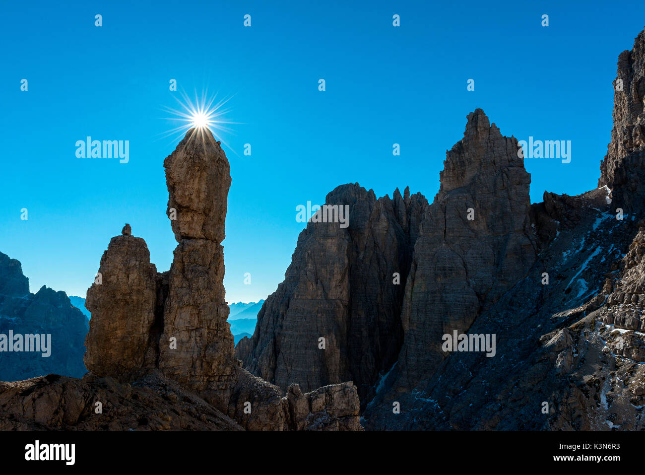 Auronzo, Dolomites, Veneto, Italy. Star sun exactly on the summit of Salsiccia near Refuge Carducci Stock Photo