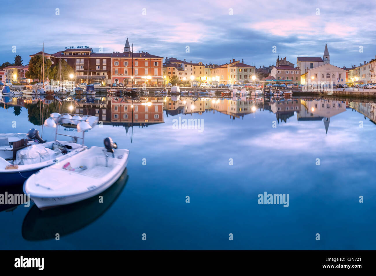 Europe, Slovenia, Primorska, Izola. Old town and the harbour with fishing boats at dusk Stock Photo