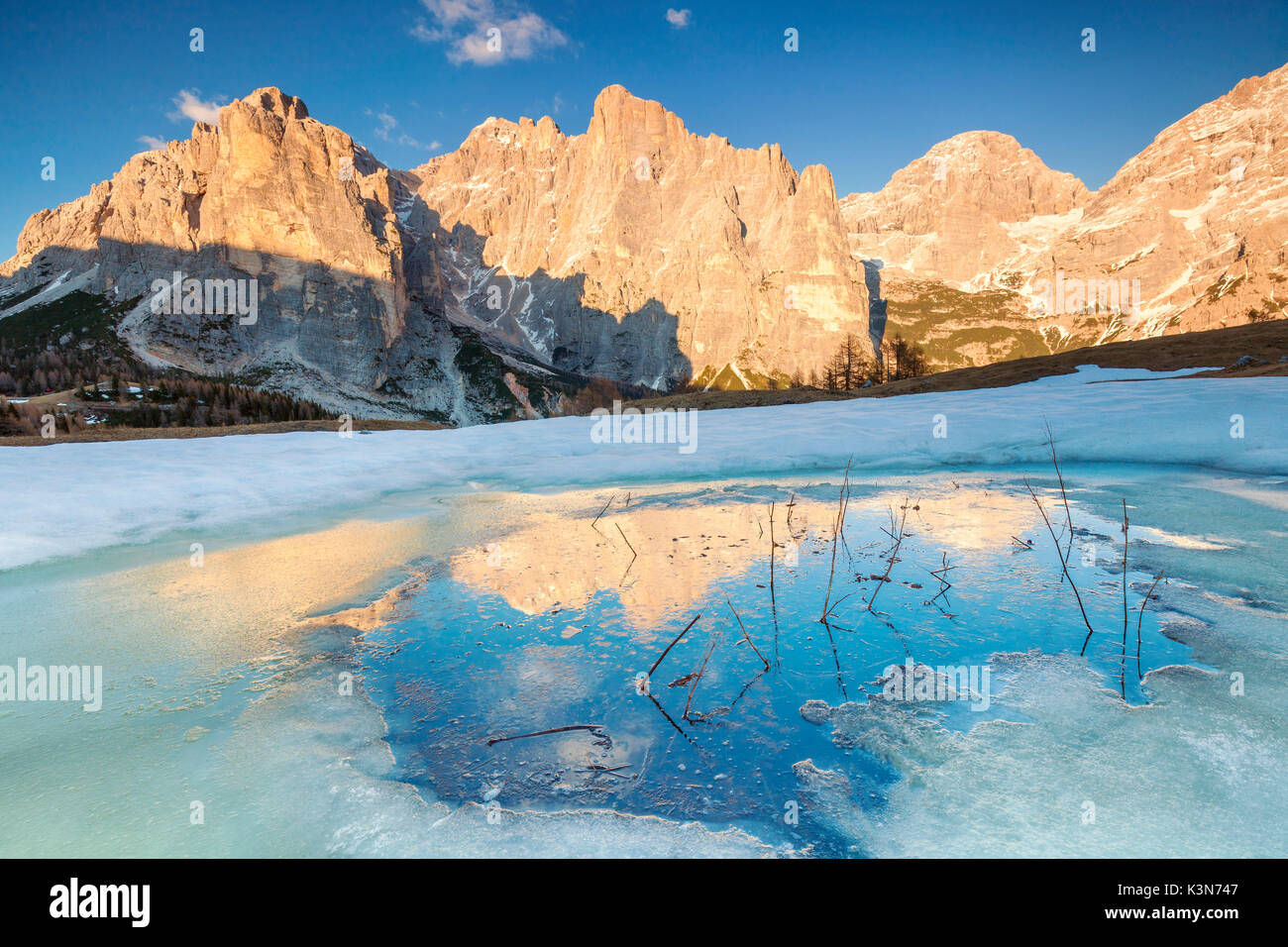 Europe, Italy, Veneto, Belluno, Agordino, Dolomites. Civetta and Moiazza mountains reflected in a water pond at sunset Stock Photo