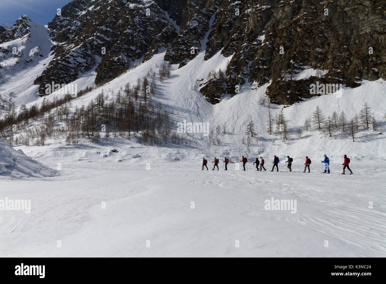 Snowshoeing on the Devero Lake frozen in winter.Natural Park of Alpe Devero, Piedmont, Italy Stock Photo